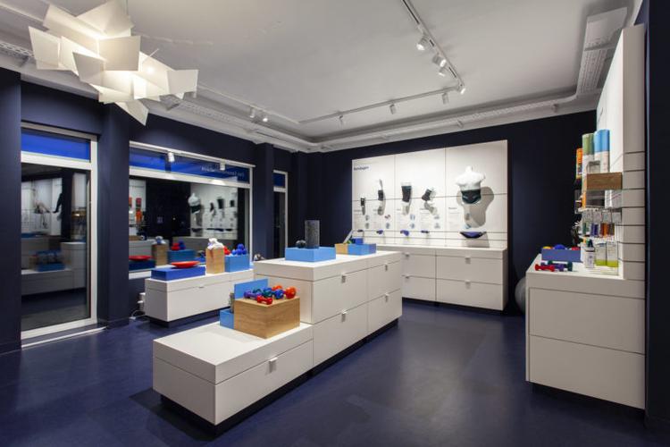 seeger医疗用品商店空间设计,地板墙壁的深蓝色与纯白色家具形成鲜明